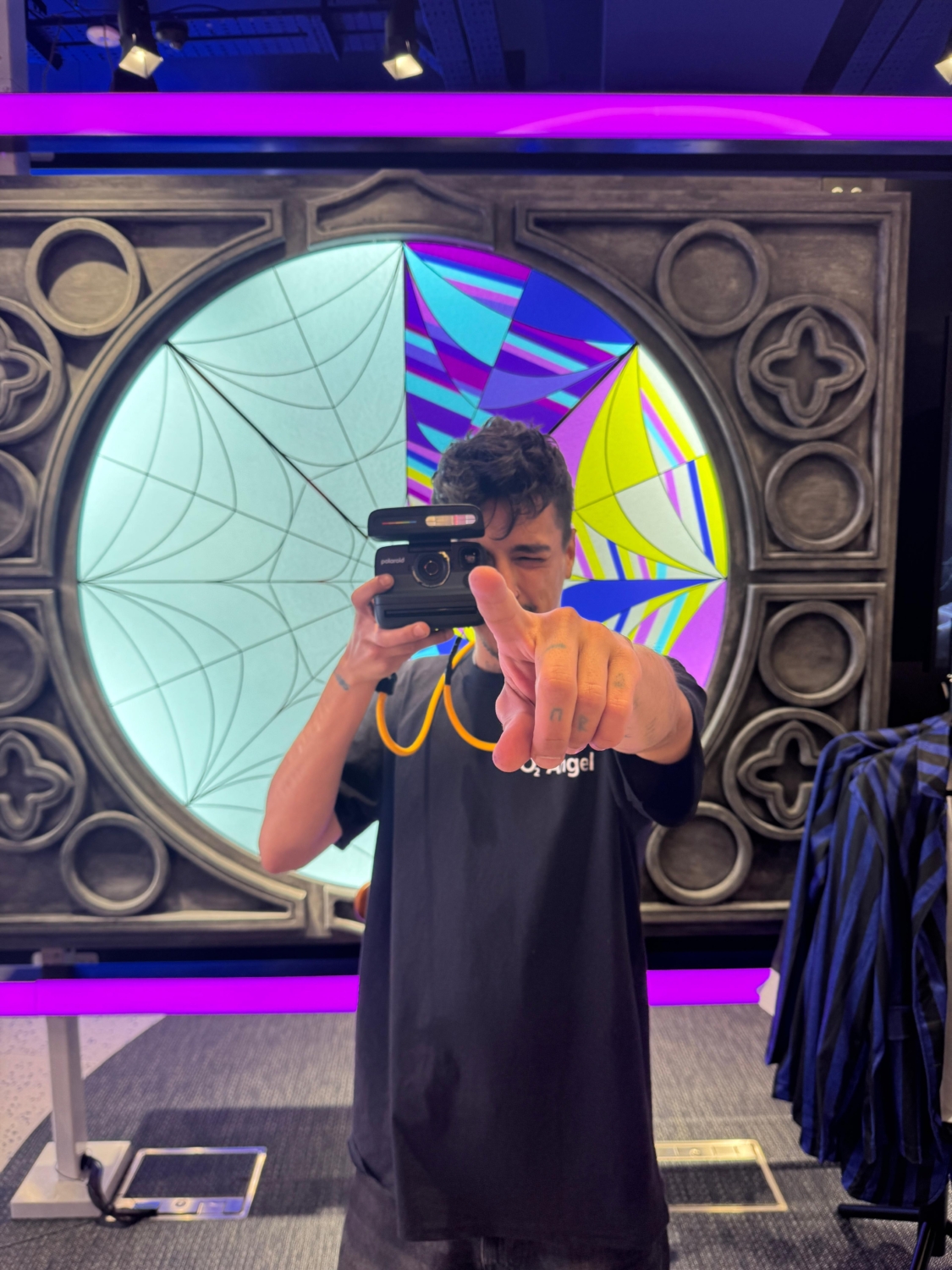 Fan holding a Polaroid camera for their printed Nevermore Yearbook portrait inside the Oxford Street O2 store during the activation weekend.